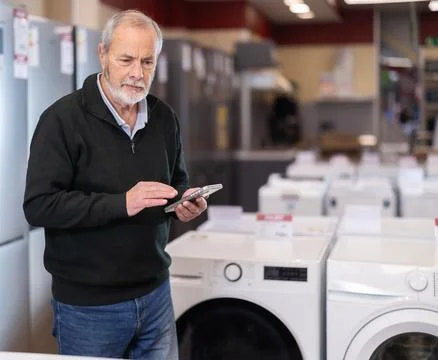 Eldery man scans qr code for dishwasher Stock-Fotos