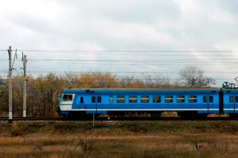 Electic train running by the rails on the fields Stock Photos