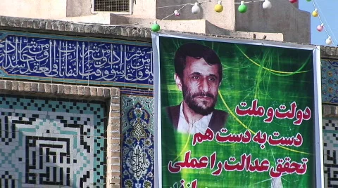 An election poster featuring Mahmoud Ahmadinejad on a wall Stock Footage