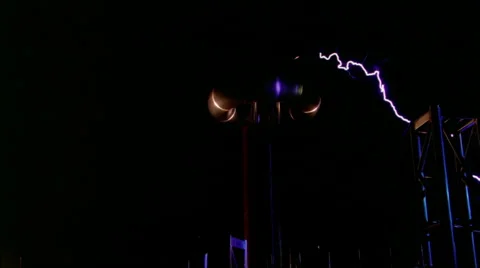 Electric arcs from Tesla coil striking metal trusses as camera dollies right Stock Footage
