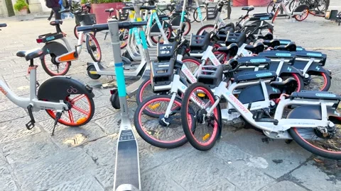 Electric bicycles piled up on the sidewalks of Florence Stock Footage 259340311