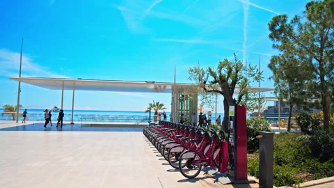 Electric bikes are parked on a dock station in the center of Monaco by the beach Stock Footage 247221500