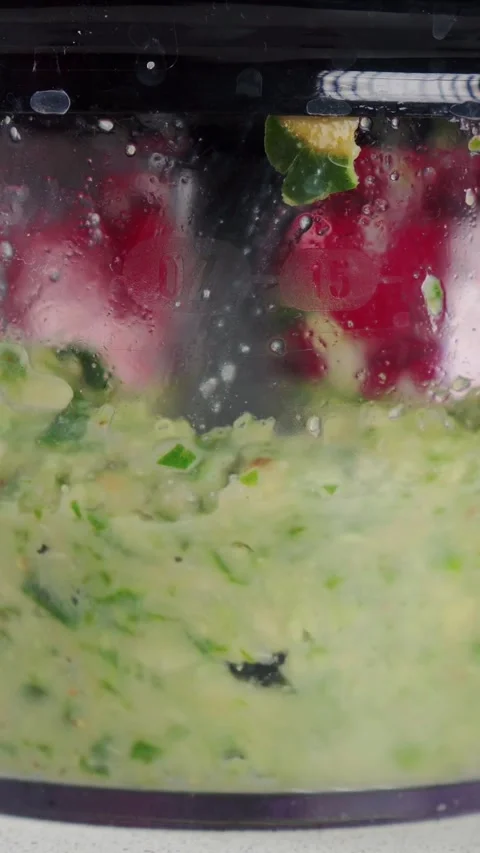 Electric blender crushes herbs and fresh ingredients into thick green paste for 스톡 동영상 346774414