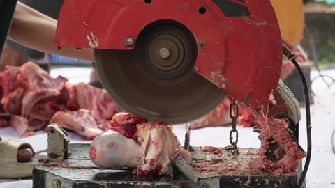 An electric bone saw machine chopping thick beef bones and raw ribs during Islam Video stock 338046348