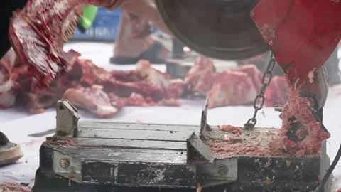 An electric bone saw machine chopping thick beef bones and raw ribs during Islam Stock-Footage 338046374