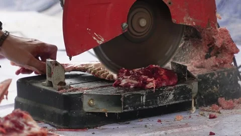An electric bone saw machine chopping thick beef bones and raw ribs during Islam Video stock 338046375