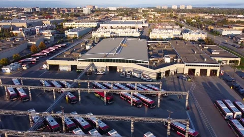 Electric buses parked at charging stations outside public transit storage, Stock Footage 237682170