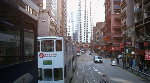 Electric cable cars and personal vehicles on typical urban street in Hong Kon Stock Footage 68179953