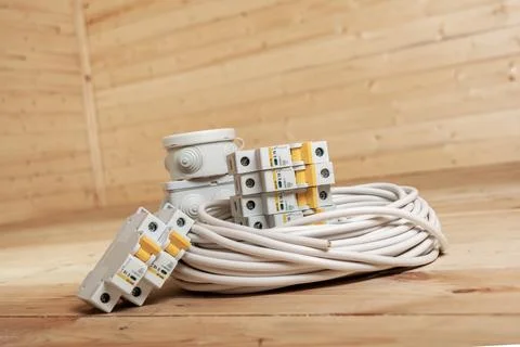Electric cables, circuit breakers, and junction boxes arranged on wooden su.. Stock Photos