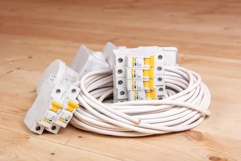 Electric cables, circuit breakers, and junction boxes neatly arranged on wood Stock Photos