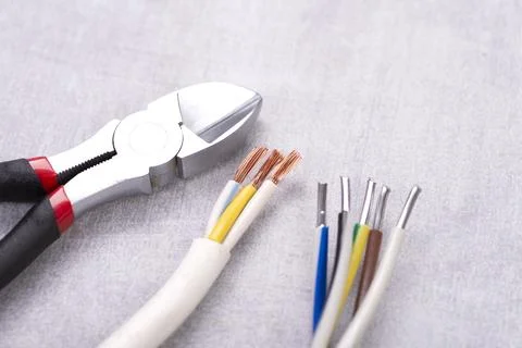 Electric cables without insulation and wire cutters on a gray table Stock Photos