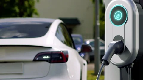 Electric car backs up to the charging station to recharge the battery. Stock Footage 325962843