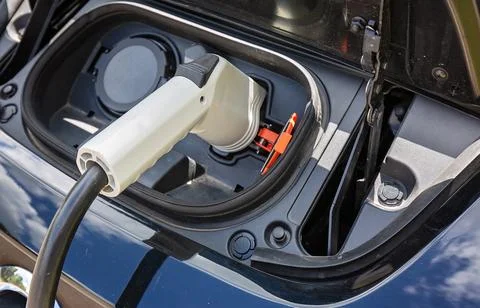 Electric car charging the battery from the electric charger Stock Photos