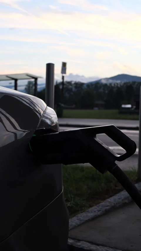 Electric car charging plug with green light at mountain station at dusk Stock Footage 342521875