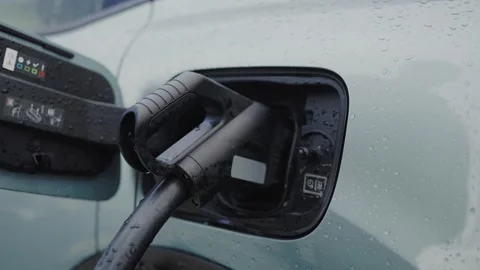 Electric Car Charging in the Rain, Focus on Plug and Port Stockbeeldmateriaal 344856761