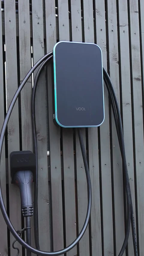 Electric Car Charging Station with a Cable Hanging on a Wooden Wall Stock Footage 338001772