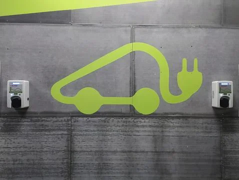 Electric car charging symbol in a parking lot with two sockets. Stock Photos