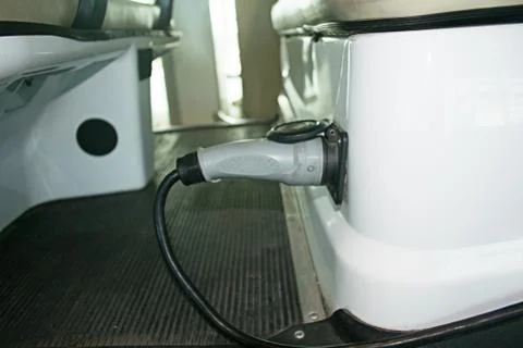 Electric Car is Charging Using a Wired Power Plug Stock Photos