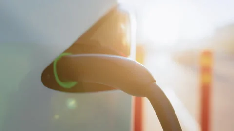Electric car with plug cord connected to charging port Stock Footage 245258492