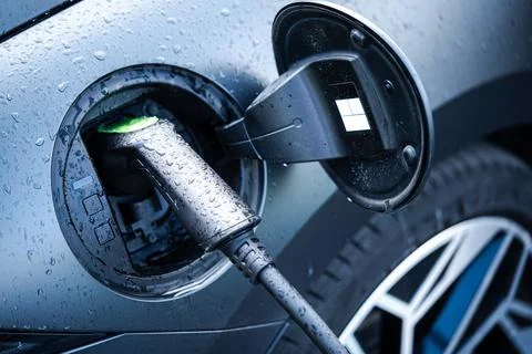 Electric car plugged in for charging Stock Photos