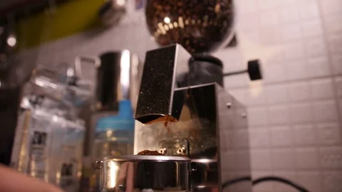 Electric coffee grinder grinds fresh roasted beans into filter holder. Slow Stock Footage 90284402