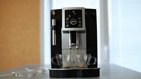 Electric coffee machine pours black coffee in two glass cups Stock Footage 77106817