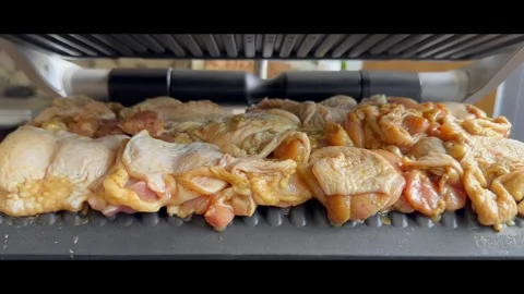 Electric contact grill closing on raw marinated chicken meat,cooking at home Stock Footage 337547793
