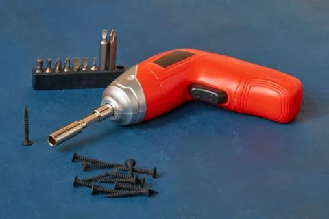 Electric cordless screwdriver with a set of bits, self-cutting screws, close- Stock Photos