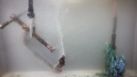 Electric current flows removing rust from a c-clamp (left) and depositing Stock Footage 318568333