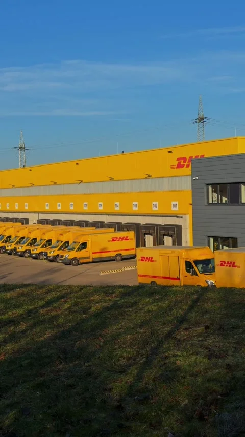 Electric delivery vehicles of German postal service charging at logistics center Stock Footage 325226426