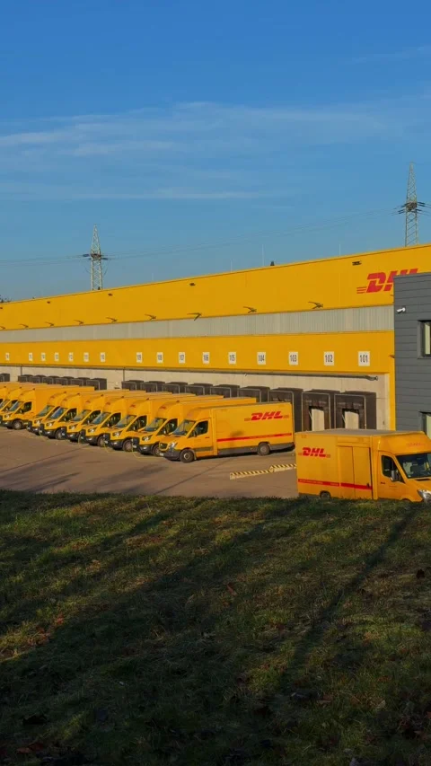 Electric delivery vehicles of German postal service charging at logistics center Stock Footage 325226432