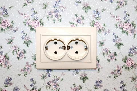 Electric double beige socket on the wall of the room in the house Stock Photos