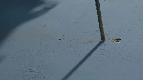 An electric drill drills a gray wall with markings with a long drill on concrete Stock Footage 194450764