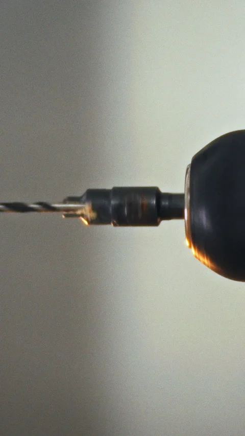 An electric drill spins a precision drill bit on its spindle in a workshop i Stock Footage 341283778