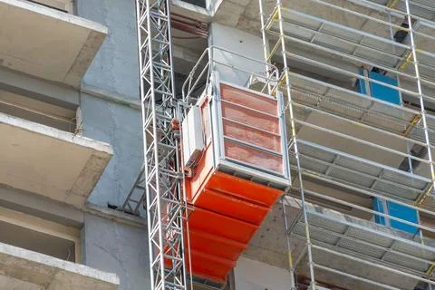 Electric elevator for construction site installed outside the facade of a b.. Stock Photos