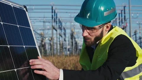 Electric engineer checking photovoltaic solar panels wearing helmet suit and Stock Footage 171187494