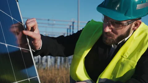 Electric engineer checking photovoltaic solar panels wearing helmet suit and Stock Footage 171188166