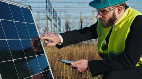 Electric engineer checking photovoltaic solar panels wearing helmet suit and Stock Footage 171189807