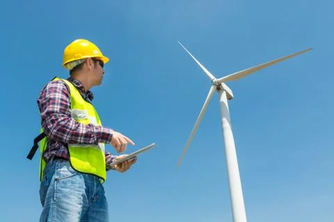 Electric Engineer use Digital Wireless Tablet Device with Wind turbine power  Stock Photos