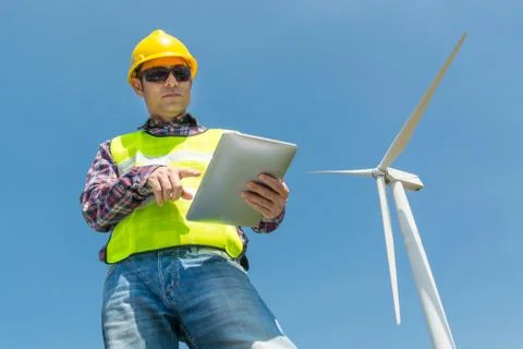 Electric Engineer use Digital Wireless Tablet Device with Wind turbine power  Stock Photos