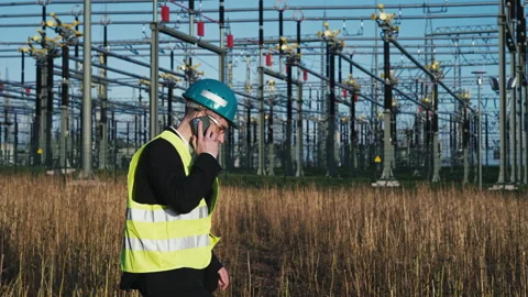 Electric engineer wearing helmet suit and safety vest making phone call with Stock Footage 171191985