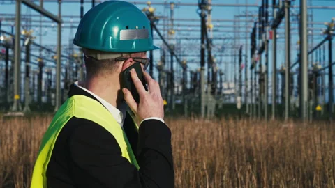 Electric engineer wearing helmet suit and safety vest making phone call with Stock Footage 171192028