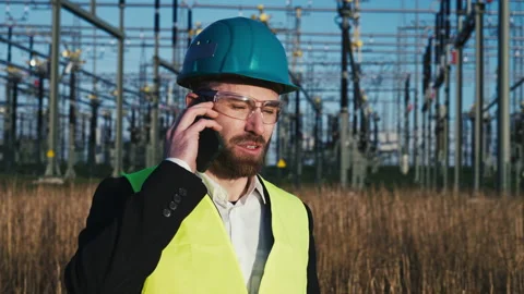 Electric engineer wearing helmet suit and safety vest making phone call with Stock Footage 171192052