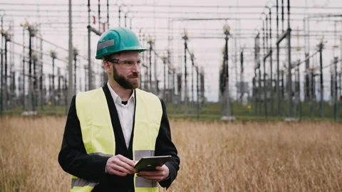 Electric engineer wearing helmet suit and safety vest at bad weather checking Stock Footage 171546092