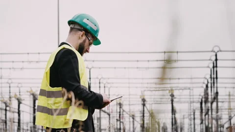 Electric engineer wearing helmet suit and safety vest at bad weather checking Stock Footage 171546664