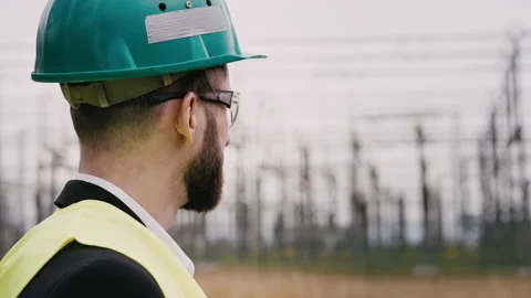 Electric engineer wearing helmet suit and safety vest at bad weather checking Stock Footage 171546780