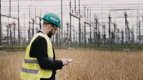Electric engineer wearing helmet suit and safety vest at bad weather checking Stock Footage 171546804
