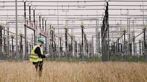 Electric engineer wearing helmet suit and safety vest at bad weather checking Stock Footage 171547313