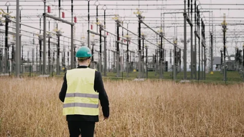 Electric engineer wearing helmet suit and safety vest at bad weather walking Stock Footage 171547403