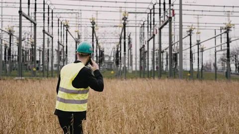 Electric engineer wearing helmet suit and safety vest at bad weather making Stock Footage 171548008
